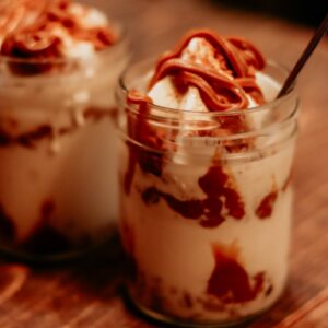 Two glasses of dessert with chocolate drizzle